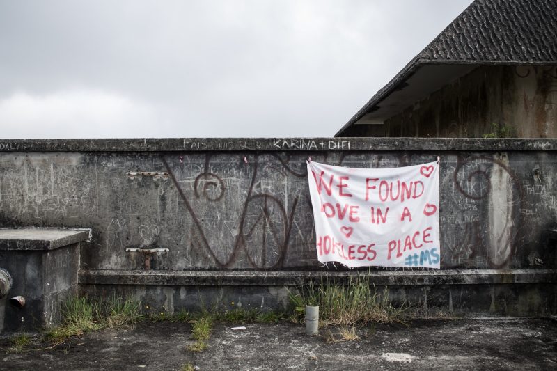 vandalized wall with hanging banner that reads 'we found love in a hopeless place'