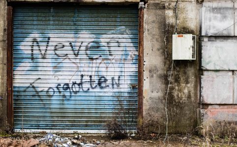 'never forgotten' spray painted on an old metal door
