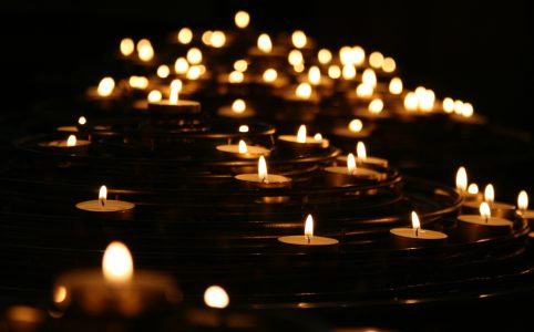 a photo of many lit candles in the dark