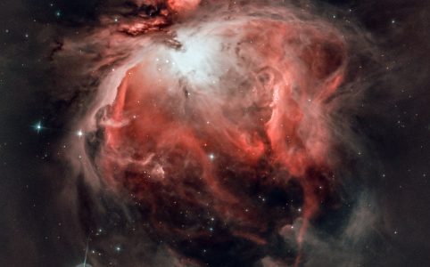 a nebula in shades of red and black surrounding a white star