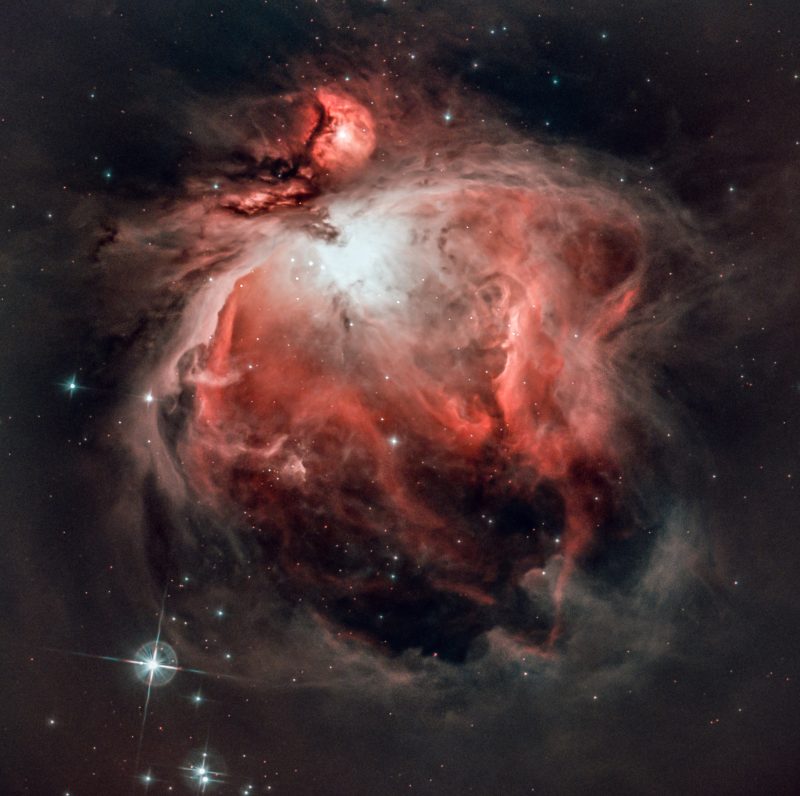 a nebula in shades of red and black surrounding a white star