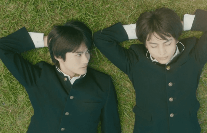 I Cannot Reach You still image showing the two main actors lying on their backs on the grass wearing school uniforms