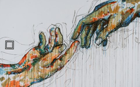 a large painting of multicolored hands reaching toward each other.